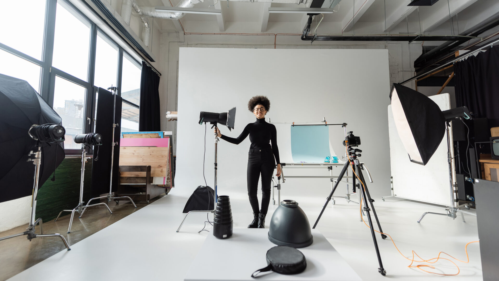 Content creator posing in a photography studio with strobe lighting